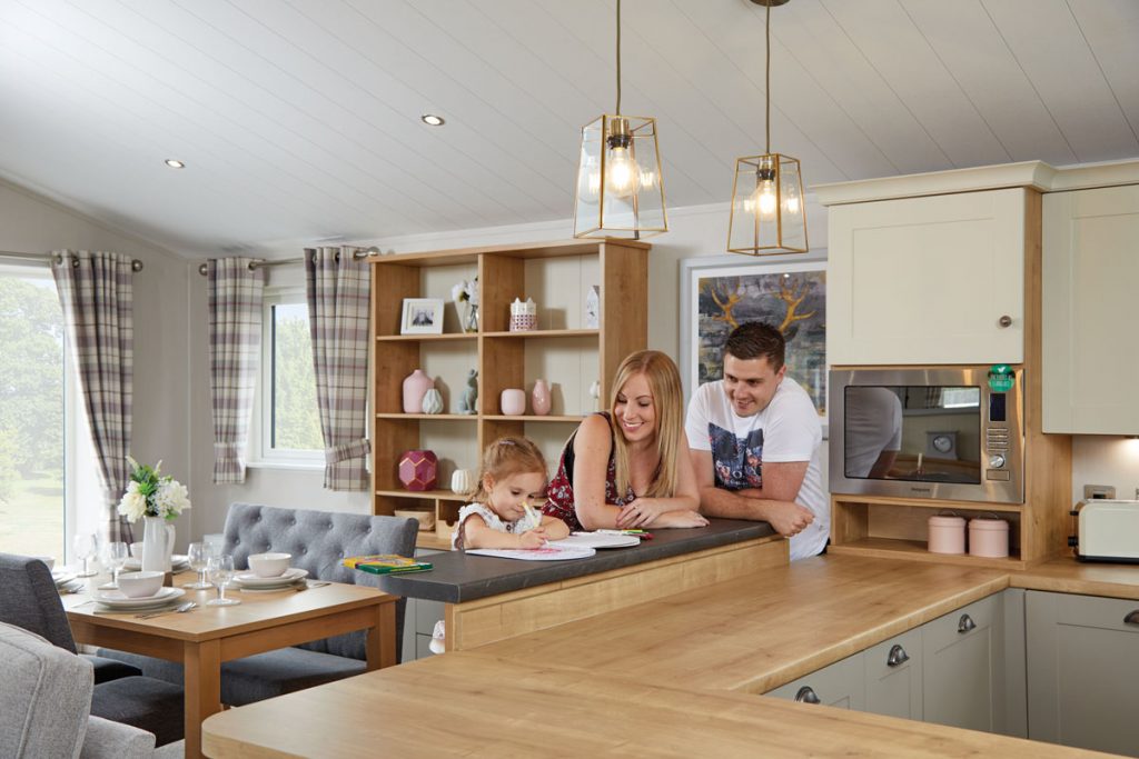 a family of three in a lodges for sale uk kitchen doing creative activities sitting at the kitchen island
