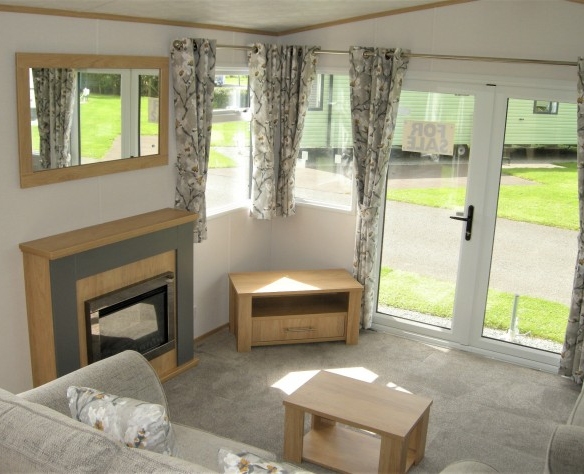 holiday parks wales living room featuring electric fireplace and doors leading outside