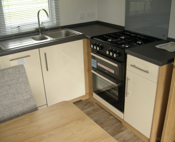holiday lodge for sale showing gas cooker and oven with splash protector on walls