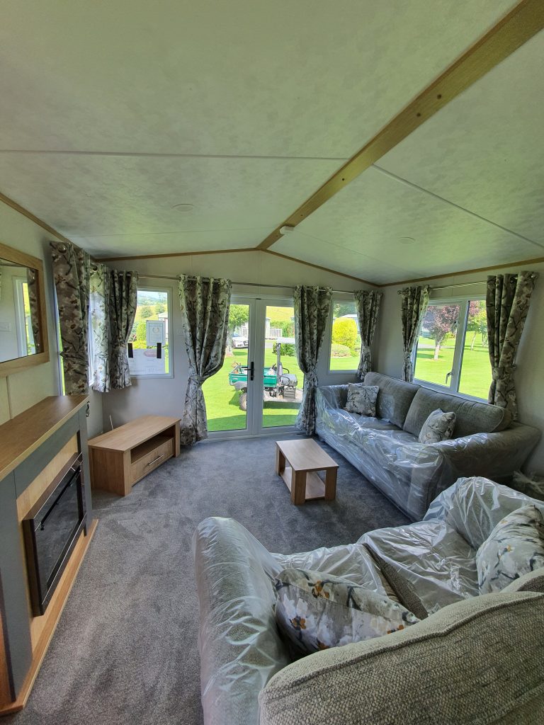 holiday lodge for sale extended view of living room with electric fireplace and space for a TV